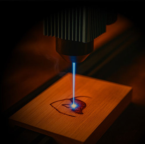 Gravure et découpe laser sur une pièce en bois à l’atelier