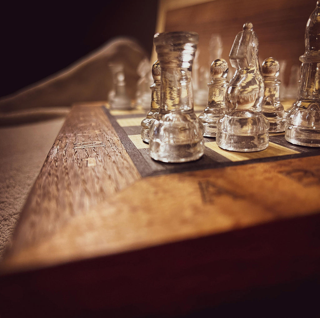 Pièces en verre poli et dépoli sur échiquier en bois