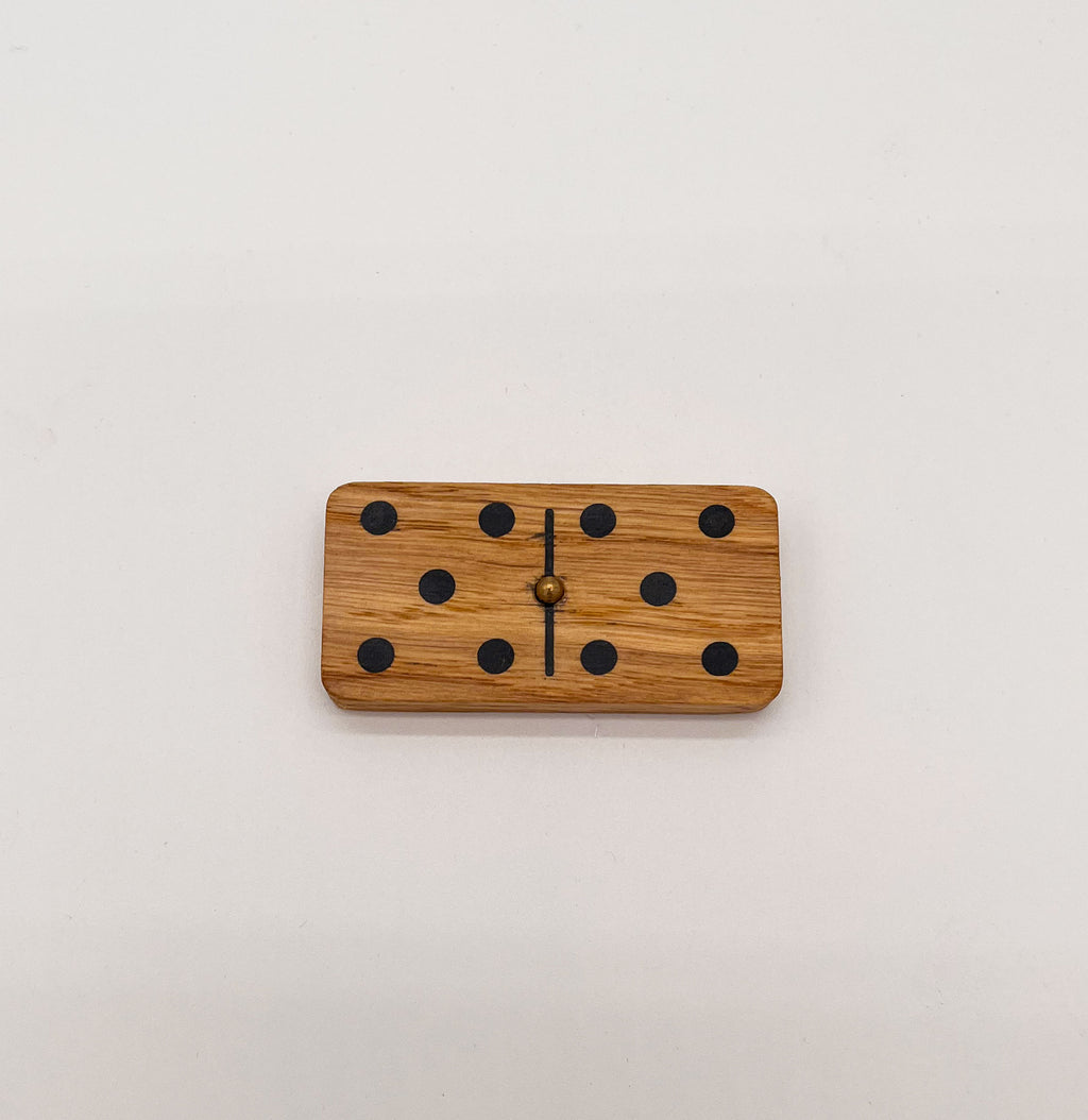 Détail d’un domino en chêne avec élément en laiton