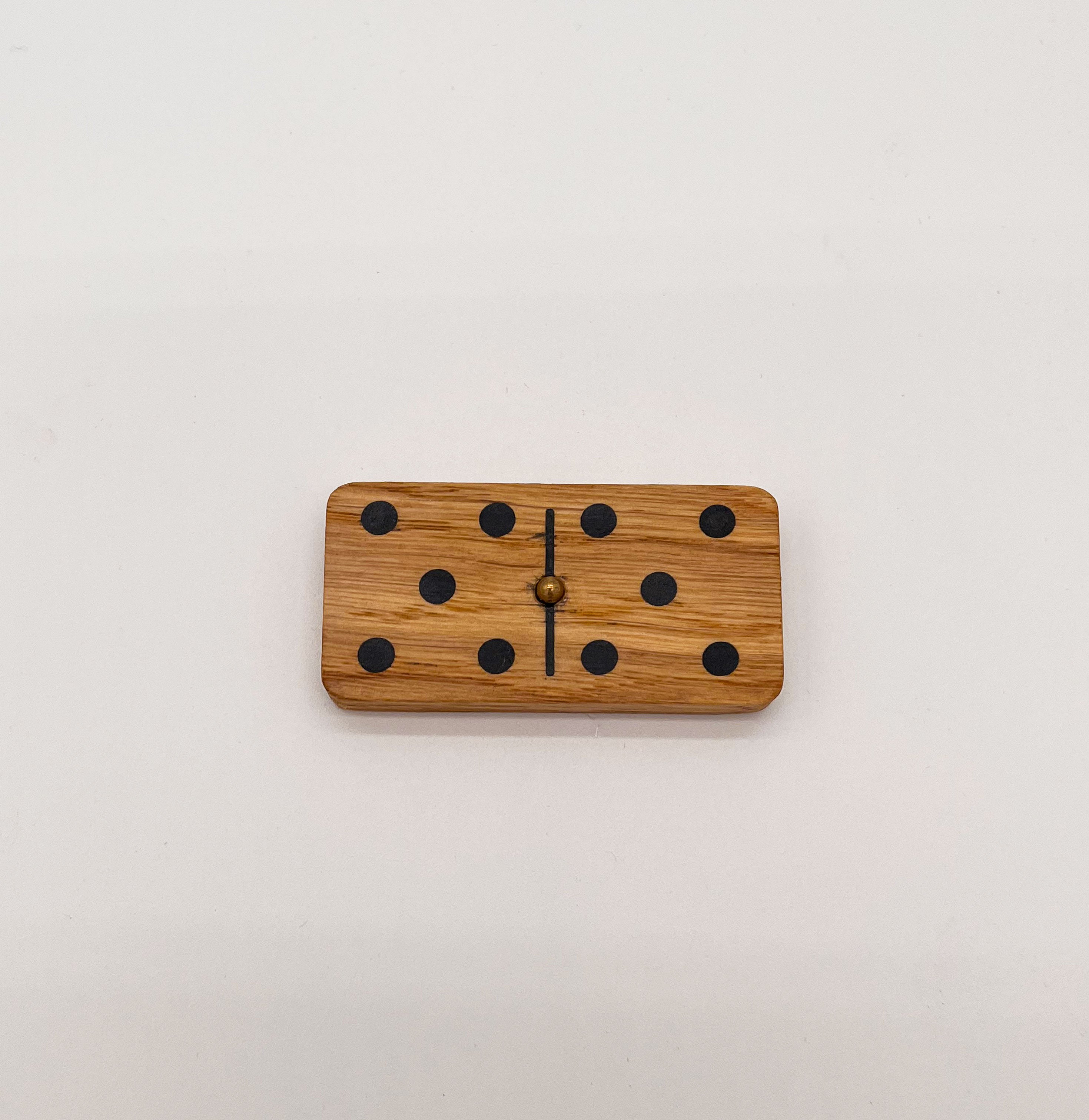 Détail d’un domino en chêne avec élément en laiton